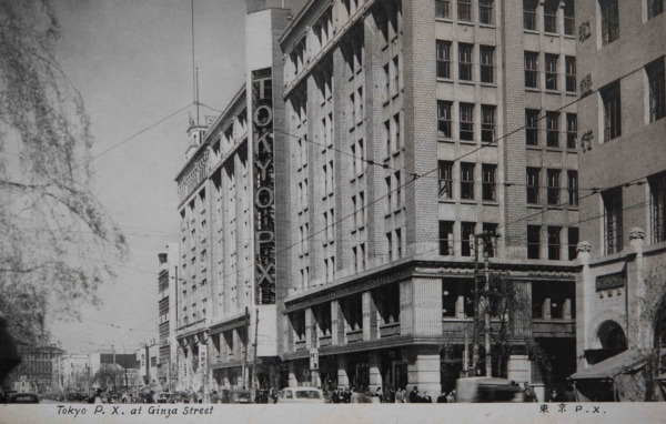 【30】終戦。占領下の銀座。GHQが松屋・服部時計店・伊東屋を接収。>太平洋戦争での敗戦後、アメリカ進駐軍はGHQ(連合軍総司令部)を置き、都内600箇所の建物を接収し、戦車で都内を行軍して回った。銀座では服部時計店、次いで松屋、伊東屋がPXとして接収され、戦前とは違う街並みとなった。PXとは“Post Exchange”の略で、米軍基地内の売店を指し、日本人客は立ち入れない、アメリカ軍人と家族のための店舗である。接収は7年間続き、1952年(昭和27年)9月に返還式が行われ、半年以上をかけて建物内外の新装、社員教育など準備を整え、翌年5月新生松屋としてオープン。新たな歴史を歩み始めることに。かたや、接収されていた1947年(昭和22年)服部時計店の小売部門の業務を継承し、株式会社和光が設立され、銀座5丁目の仮営業所が設けられた。接収解除後、現在の和光本館にて事業を開始。これを記念し、ショーウインドウを当時の気鋭のデザイナーが競作し、以後現在に至るまで、和光のショーウインドウは、「銀座の顔」として定着した。【30】1946年(昭和21年)・Tokyo P.X. at Ginza Street