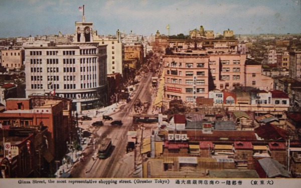 【28】銀座の象徴、和光。格調と華麗さを体現。銀座のシンボル、和光の時計塔は1932（昭和7）年竣工。緩やかな弧を描くネオ・ルネッサンス様式。塔の高さは9m、その上に8mの尖塔と避雷針が付属する。四方にある時計文字盤は東西南北を向いており、直径は2.4m。建物の外装材は、関東大震災直後、設計段階で予定されていたテラコッタからより強靭な天然御影石へと変更され当時最高の技術が注ぎ込まれた。時計文字盤や窓部分は、ブロンズでアラベスク（唐草）の繊細な透かし模様の装飾などが施され、店内壁面は伊から輸入された大理石を使用。設計は、後に東京国立博物館本館、旧第一生命館を手がける渡辺仁。日本建築にモダニズムの波が押し寄せた昭和初期に、この建物が重厚華麗なネオ・ルネッサンス様式の姿を身に纏った理由は、当時の服部時計店図案部長、八木豊次郎の強いこだわりに由来する。伝統的な様式を踏襲しながらも新時代の感覚を反映させ、商号である「H」を刻んだレリーフなどディティールに配した。モボ、モガが闊歩する昭和の銀座と石造りのクラシカルな建物が見事に共存する景観が立ち現われた。1940年（昭和15年）頃【28】（大東京）帝都随一の商店街銀座大通り