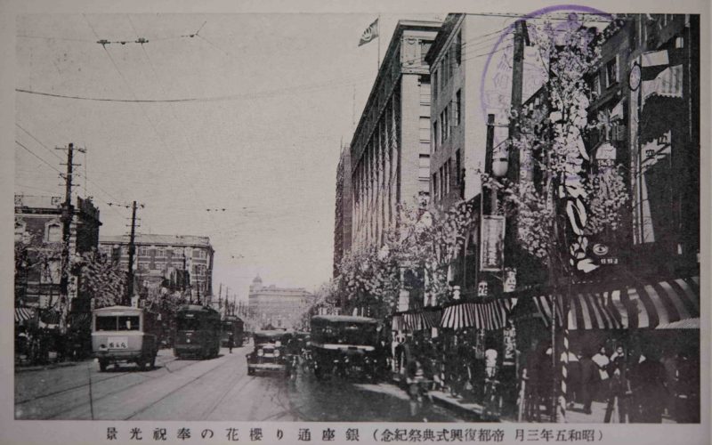 【13】バラック装飾から始まった復興建築。関東大震災からの復興建築 。焼け野原に出現したのは、仮設のバラックであった。仮店舗には「バラック装飾」と呼ばれる若い建築家達のアート運動が見られた。今和次郎が結成した「バラック装飾社」が有名で、住宅や商店などのバラックのファサードにペンキで絵を描くなどの活動を展開した。代表作である銀座のカフェ・キリンでは、怪獣のように口を開けたキリンを激しいタッチで描き、神田の東条書店には「野蛮人の装飾をダダイズムで」として、動物と渦巻き紋様を描いた。その後、復興が進みバラックの建設が減り活動も自然消滅した。彼らに対して、分離派建築会、芸術至上主義的な立場から厳しい批判に対し、今和次郎は世相風俗の表層的な部分にこそ宿る美の存在を主張した。現在『日本の近代建築（下）』岩波新書（1993）の中で、建築家 藤森照信氏は「モダンデザイン終了後のポストモダンの傾向の一つにほかならない」とその先進性を評価している。1930年（昭和5年）【13】（昭和五年三月 帝都復興式典祭記念）銀座通り櫻花の奉祝光景